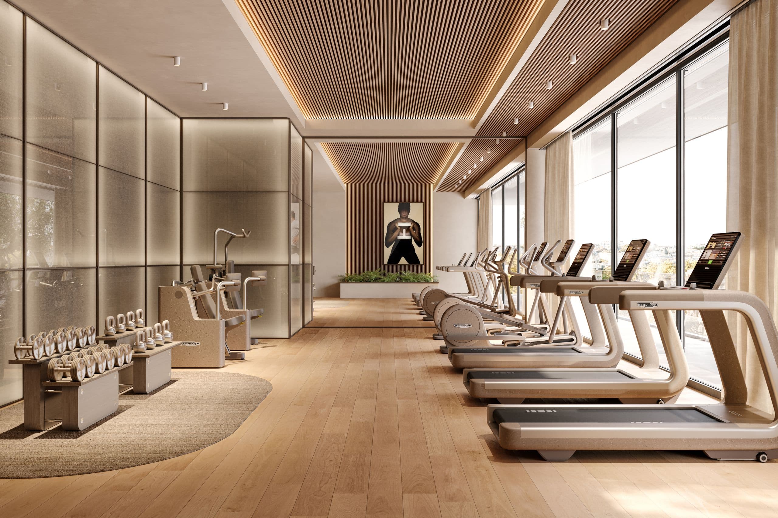 A wood-and-stone gym interior lined with Technogym Sand Stone treadmills and dumbbells in warm sand tones