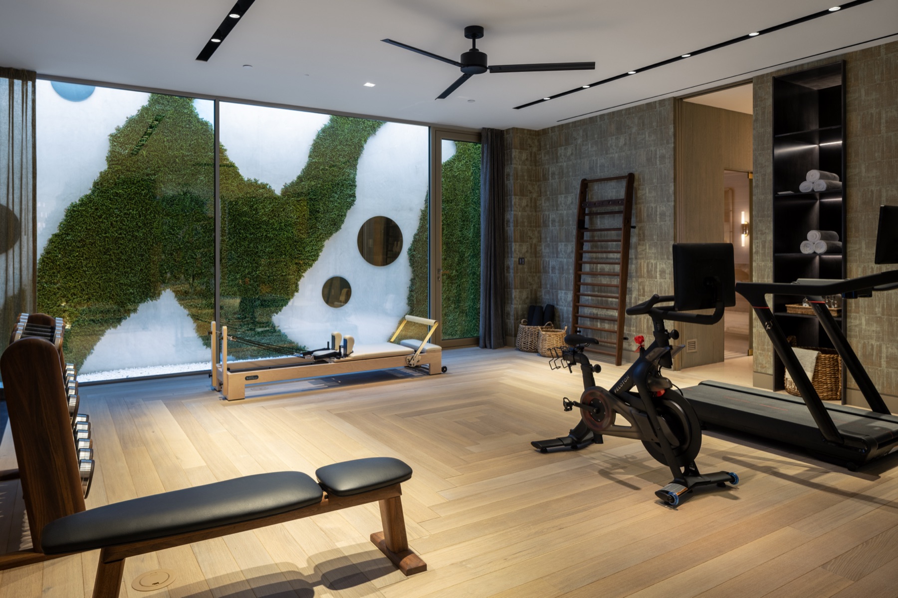 Pilates reformer and green wall in the lower-level gym at 3512 Ocean Boulevard